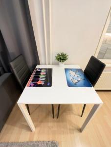 Biały stół z obrazami w pokoju w obiekcie Railway&bus station studio w mieście Oulu