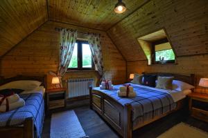 um quarto com 2 camas num chalé de madeira em Stacja Żubracze em Żubracze