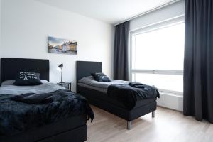 1 dormitorio con 2 camas y ventana en Rauma City Center Studios, en Rauma
