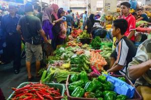 a group of people standing around a market with vegetables at Welcome,3R2B Cheerful Family's Homestays Sandakan. in Sandakan