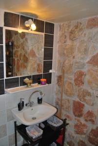 baño con lavabo y pared de piedra en Estate Tsiati - Κτήμα Τσιάτη, en Nauplia