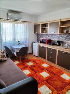 a kitchen and a living room with a table and a couch at Apartament Home Comfort in Orşova