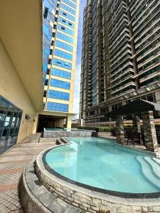 a large swimming pool in a building with tall buildings at Grand Riviera Suits in Manila