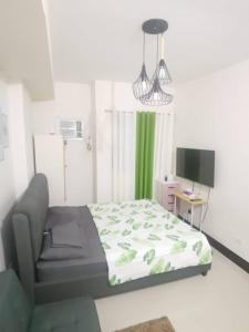 a bedroom with a bed and a chair and a television at Grand Residences Studio Unit - Walking Distance to IT Park in Cebu City