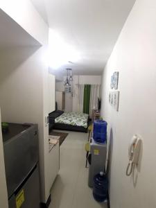a small room with a bed in the middle of a room at Grand Residences Studio Unit - Walking Distance to IT Park in Cebu City