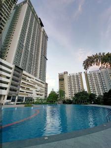 a large swimming pool in front of tall buildings at Grand Residences Studio Unit - Walking Distance to IT Park in Cebu City