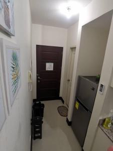 a hallway with a black door and a refrigerator at Grand Residences Studio Unit - Walking Distance to IT Park in Cebu City