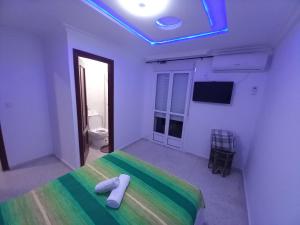 a bedroom with a bed with a green and white blanket at Casa Salma in Seville