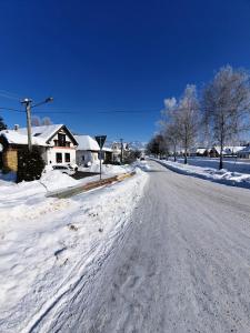 a snow covered street with houses and a snow covered road at Chalupa MATEJKO in Liptovský Mikuláš
