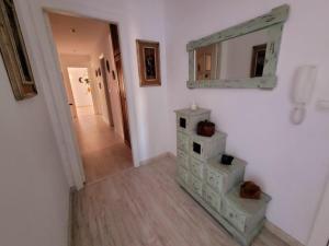 a hallway with a dresser and a mirror on a wall at Camiño á praia in Fisterra