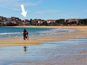a person riding a bike on the beach at Camiño á praia in Fisterra