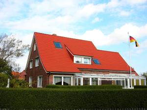 a red roofed house with a flag on it at Haus Rieckhoff in Borkum