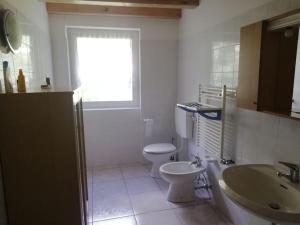 La salle de bains est pourvue de toilettes, d'un lavabo et d'une fenêtre. dans l'établissement Appartamento Dimaro Folgarida Daolasa ski, à Monclassico