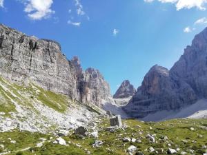 - une vue sur une montagne avec des rochers et de l'herbe dans l'établissement Appartamento Dimaro Folgarida Daolasa ski, à Monclassico