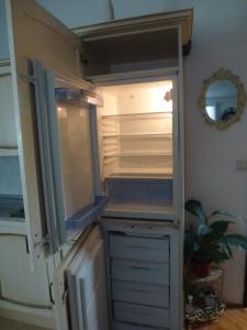 una nevera vacía con la puerta abierta en una cocina en Apartments Juraj, en Drasnice