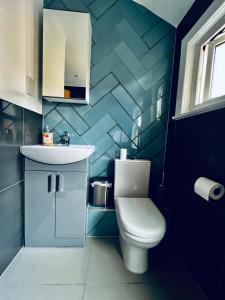 La salle de bains est pourvue de toilettes et d'un lavabo. dans l'établissement Neils Place hosted by AirOperate, à Londres
