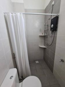 ein Bad mit einem WC und einer Dusche mit einem Duschvorhang in der Unterkunft Kuala Selangor Cozy Homestay in Kuala Selangor