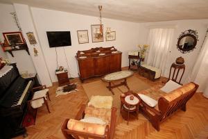 a living room filled with furniture and a piano at Apartments Juraj in Drasnice