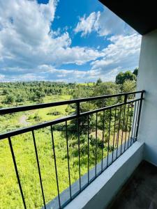 einen Balkon mit Blick auf ein grünes Feld in der Unterkunft Zoe Homes 1br and 2br Apartment Greypoint 406 in Kericho