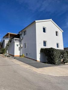 a white building on the side of a street at Apartments Frigan in Maslenica