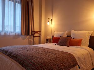 um quarto com uma cama com almofadas e uma janela em Gîte de l’Etabli em Cellettes