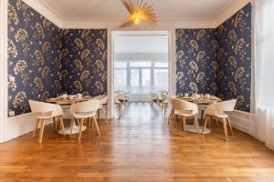 a dining room with tables and chairs and a ceiling at Hôtel Échappée en Baie - Chambres climatisées -Parking privé gratuit dont forfaits bornes électriques réservable in Saint-Valéry-sur-Somme