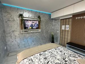Schlafzimmer mit einem Bett und einem TV an der Wand in der Unterkunft Exclusiv Room in Iaşi