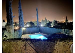 a swimming pool in a yard with trees at night at Granada Sights in Las Gabias