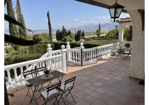 un patio con una valla blanca, mesas y sillas en Granada Sights en Las Gabias