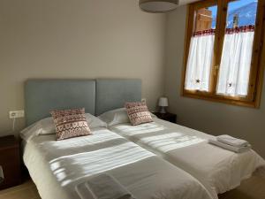 a bedroom with two beds with white sheets and a window at Apartamento Casa Francho 3 in Panticosa