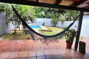 a hammock on a patio with a pool at Karina House in Jardín América