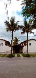 two palm trees in front of a building at CONDOMÍNIO ILHAS DO JUQUEHY in Sao Paulo