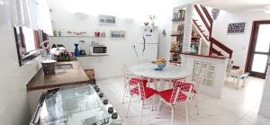 a kitchen with a table and chairs in a room at CONDOMÍNIO ILHAS DO JUQUEHY in Juquei