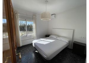 una camera con un letto bianco e una finestra di Granada Sights a Las Gabias