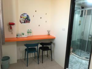 a bathroom with a bar with two chairs and a shower at Yuan Dudu Homestay in Jinning