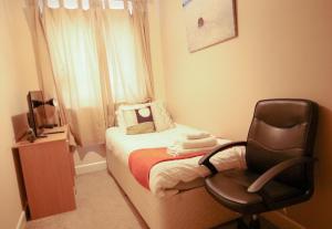 um pequeno quarto com uma cadeira e uma cama em Bellengers Apartments em Kidlington
