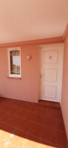 um quarto com uma porta, uma janela e um piso de azulejo em Super-cute colourful, cozy flat em Saint-Raphaël