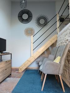 een woonkamer met 2 stoelen en een trap bij Mini Gite Les Marais Beaugency in Beaugency