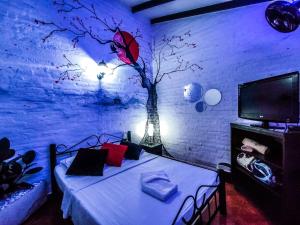 um quarto com uma cama com uma árvore pintada na parede em Melao Hostel Campestre y Vivero em Palmira