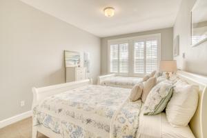 a white bedroom with two beds and a window at The Driftwood in Depoe Bay