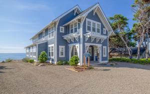 a blue house with a sign in front of it at The Driftwood in Depoe Bay