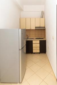 a kitchen with a stainless steel refrigerator and cabinets at Sulo Villa in Vlorë