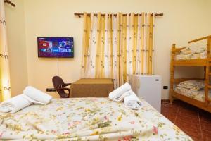 a bedroom with a bed and a tv on the wall at Sulo Villa in Vlorë