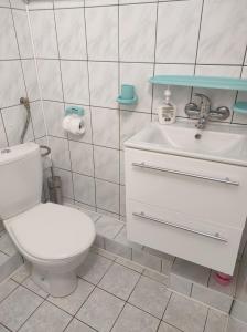 a bathroom with a white toilet and a sink at Pokoje gościnne Cuma in Łeba +28 photos