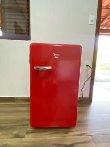 a red refrigerator is sitting in a room at Chalés Vista da Serra in Piauí