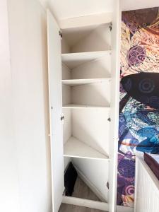 a closet in a bedroom with white shelves at Lovely in Bordeaux