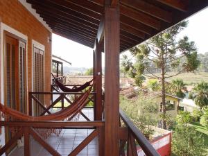 a porch with a hammock on the side of a house at Pousada Rural Paraíso in Águas de São Pedro