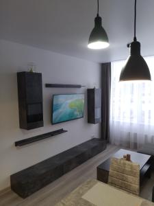 a living room with a couch and a tv on the wall at Bruklinas in Šiauliai