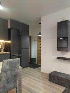 a kitchen with black cabinets and a table in a room at Bruklinas in Šiauliai +18 photos