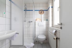 uma casa de banho com um chuveiro, um WC e um lavatório. em Hotel am Ludwigsplatz em Giessen